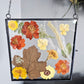 Vintage style black square frame with pressed rust orange, tan, natural and yellow flowers and leaves