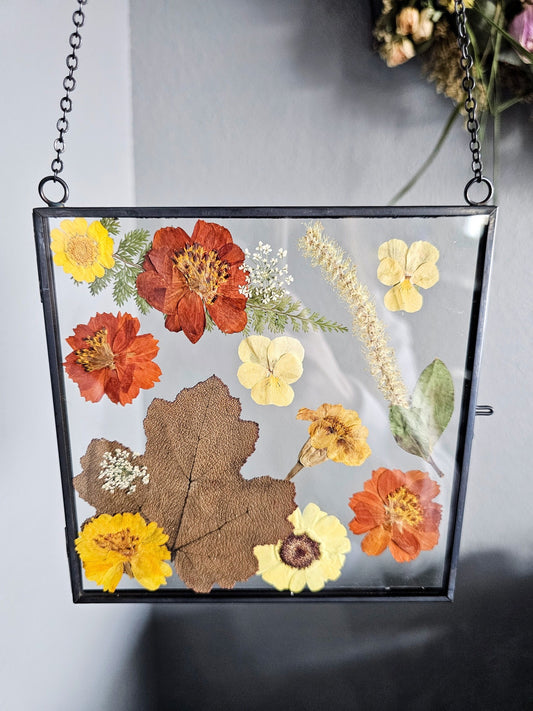 Vintage style black square frame with pressed rust orange, tan, natural and yellow flowers and leaves